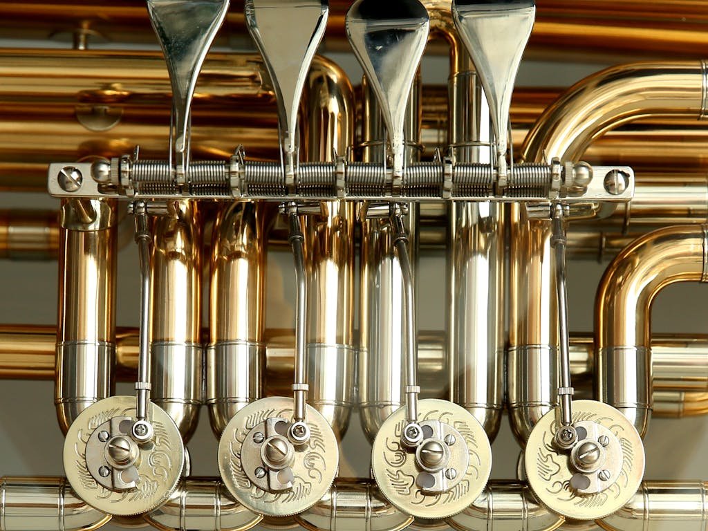 Detailed close-up of shiny brass musical instrument valves showcasing intricate metalwork.